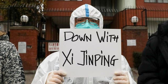 A person holds a banner during a protest in solidarity against COVID-19 restrictions in mainland China, during the memorial service for the Urumqi fire victims outside the Chinese Consulate in Toronto on November 29, 2022.