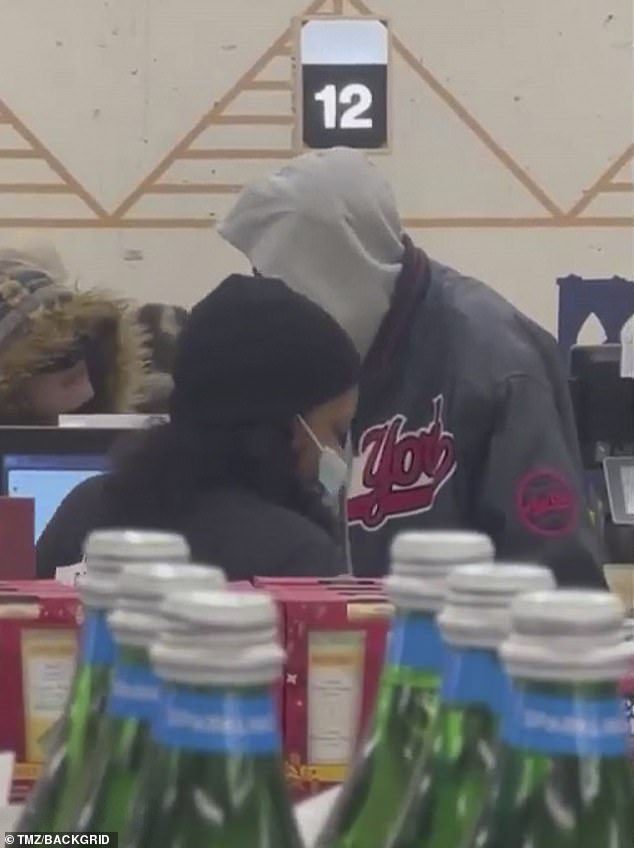 Friendly: When the cashier called for their snacks, the friends were seen chatting and exchanging 'smiles at the checkout'